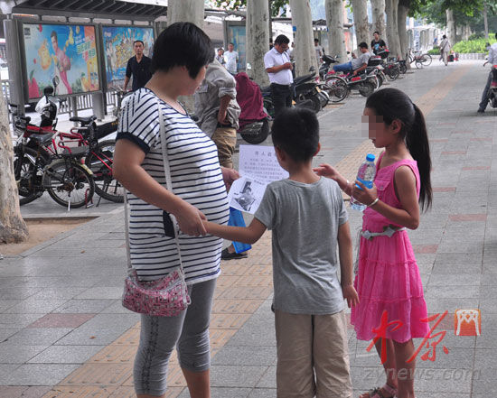 妹妹在紫荆山广场附近发放寻人启事和纯净水希望市民帮忙寻找