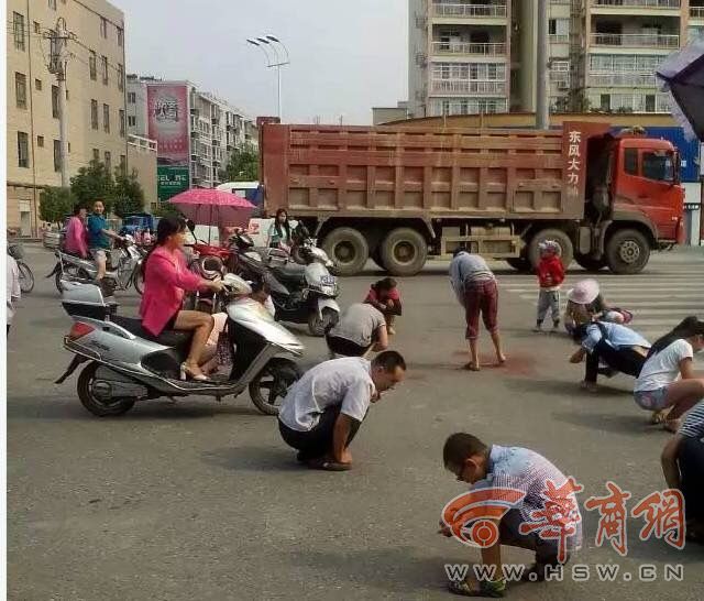 汉中勉县城区新兴北路108国道十字路口众人捡金子卖钱