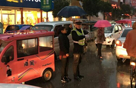 雨天女子为执勤民警撑伞