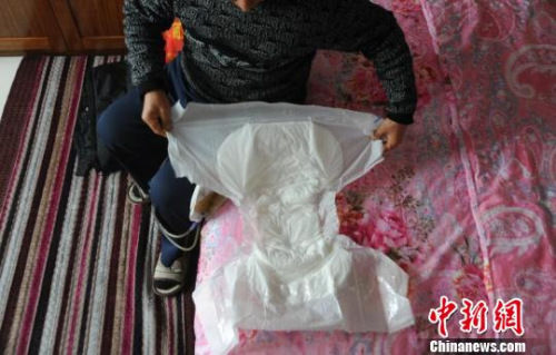 因为尿管会漏，申建军（化名）需要时常带着大号成人纸尿裤。　胡健　摄