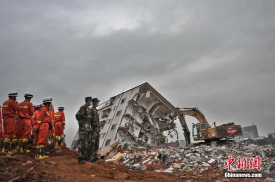 深圳山体滑坡 消防员乘挖掘机进土坑救援。图片来源：视觉中国