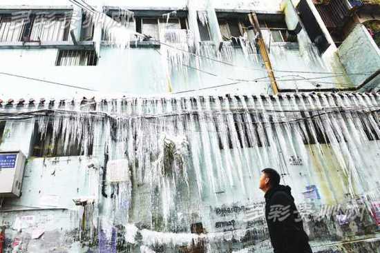 贵州一老楼水管爆裂 雨棚挂满冰柱引路人观望