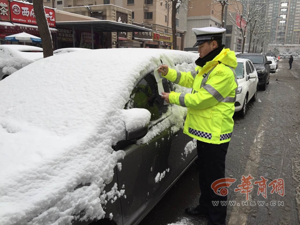 西安交警冒雪贴条 只纠正不罚款温馨提示受点