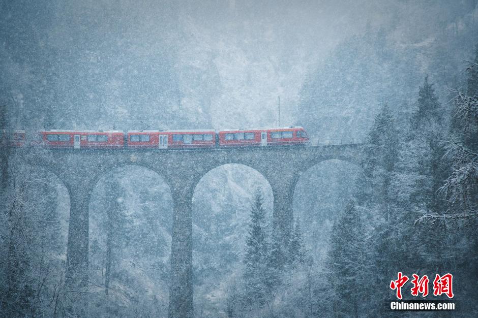 瑞士列车雪中驶过百年大桥 美如童话仙境