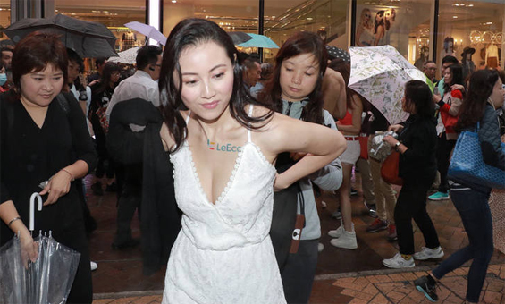 昔日港姐下雨天闹市赚钱 穿深V装当众换衣(图)