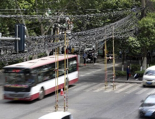 东关正街线缆垂落影响通行 缠住车轮两人挂倒在地