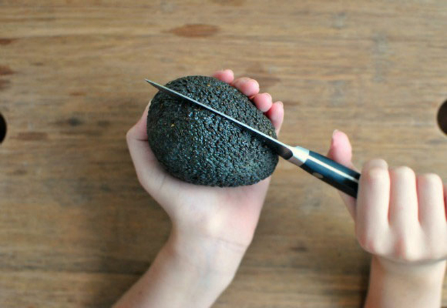 牛油果(酪梨)握在手里,用刀沿著牛油果外围划一圈